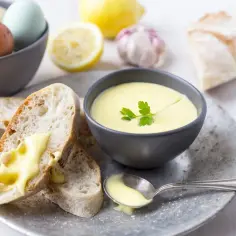 Kremowe aioli z czosnkiem i cytryną, podane z chrupiącym pieczywem i jajkami.