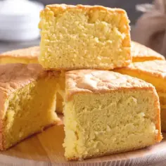 Puszyste kawałki biszkoptu ułożone na desce. Ile piec biszkopt? Wystarczy tyle, by zadowolić każdego!