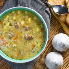 Aromaticzny zupa krupnik przepis babci, pełna ziemniaków, marchewki i mięsa, podana z chlebem.
