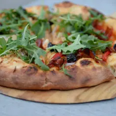 Pyszna pizza z rukolą i oliwkami, idealna na szybki przepis na ciasto do pizzy.
