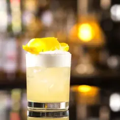 Klasyczny whisky sour przepis: orzeźwiający koktajl z pianką i skórką cytryny. Idealny na każdą okazję.