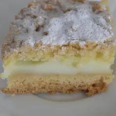 Szybkie ciasto z budyniem, puszyste i delikatne, posypane cukrem pudrem. Idealne na deser.