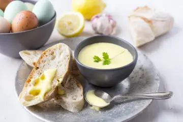 Kremowe aioli z czosnkiem i cytryną, podane z chrupiącym pieczywem i jajkami.